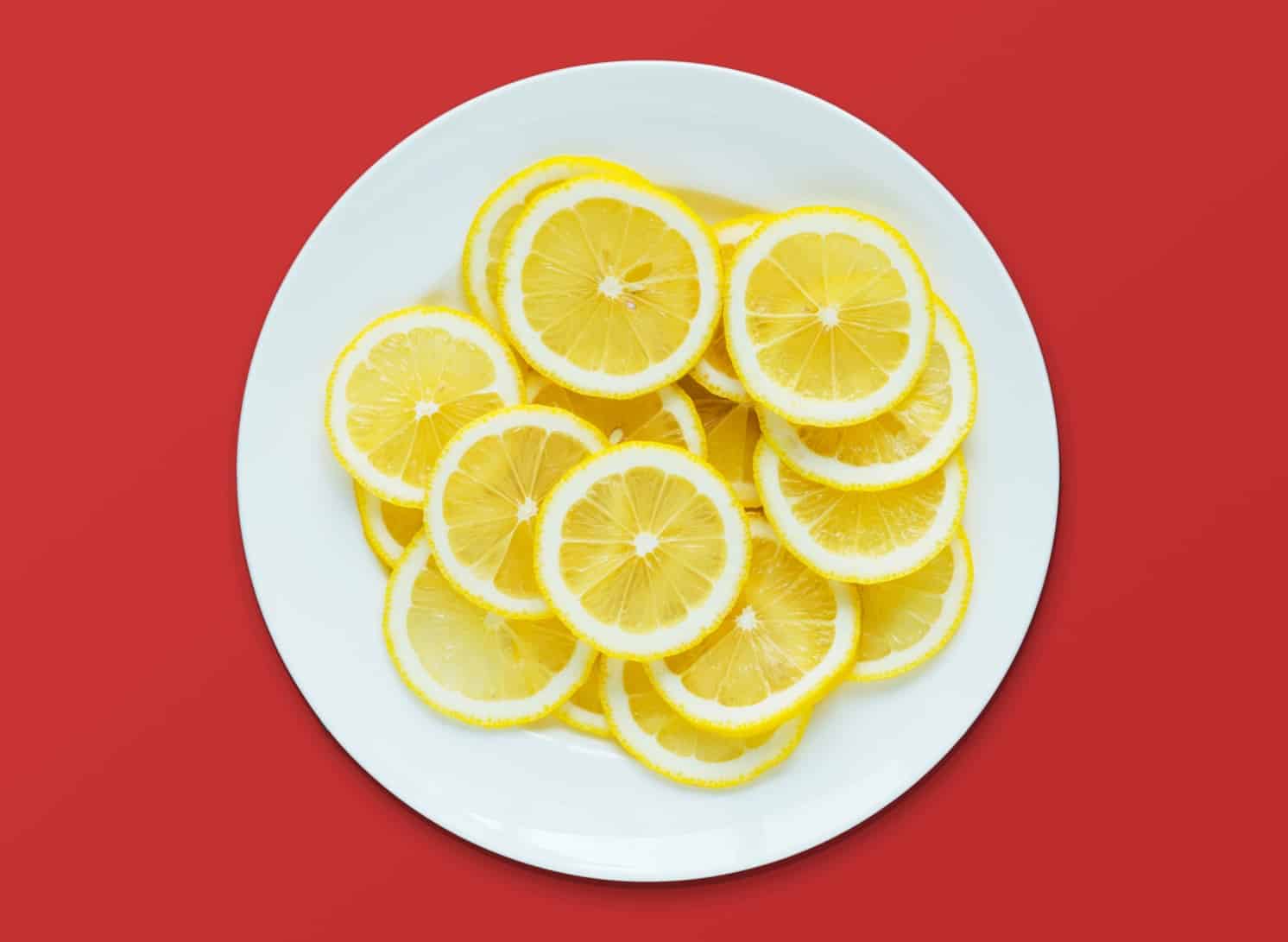 Lemon on a plate with red background